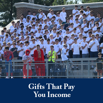 Students singing the National Anthem at a school game. Links to Gifts That Pay You Income